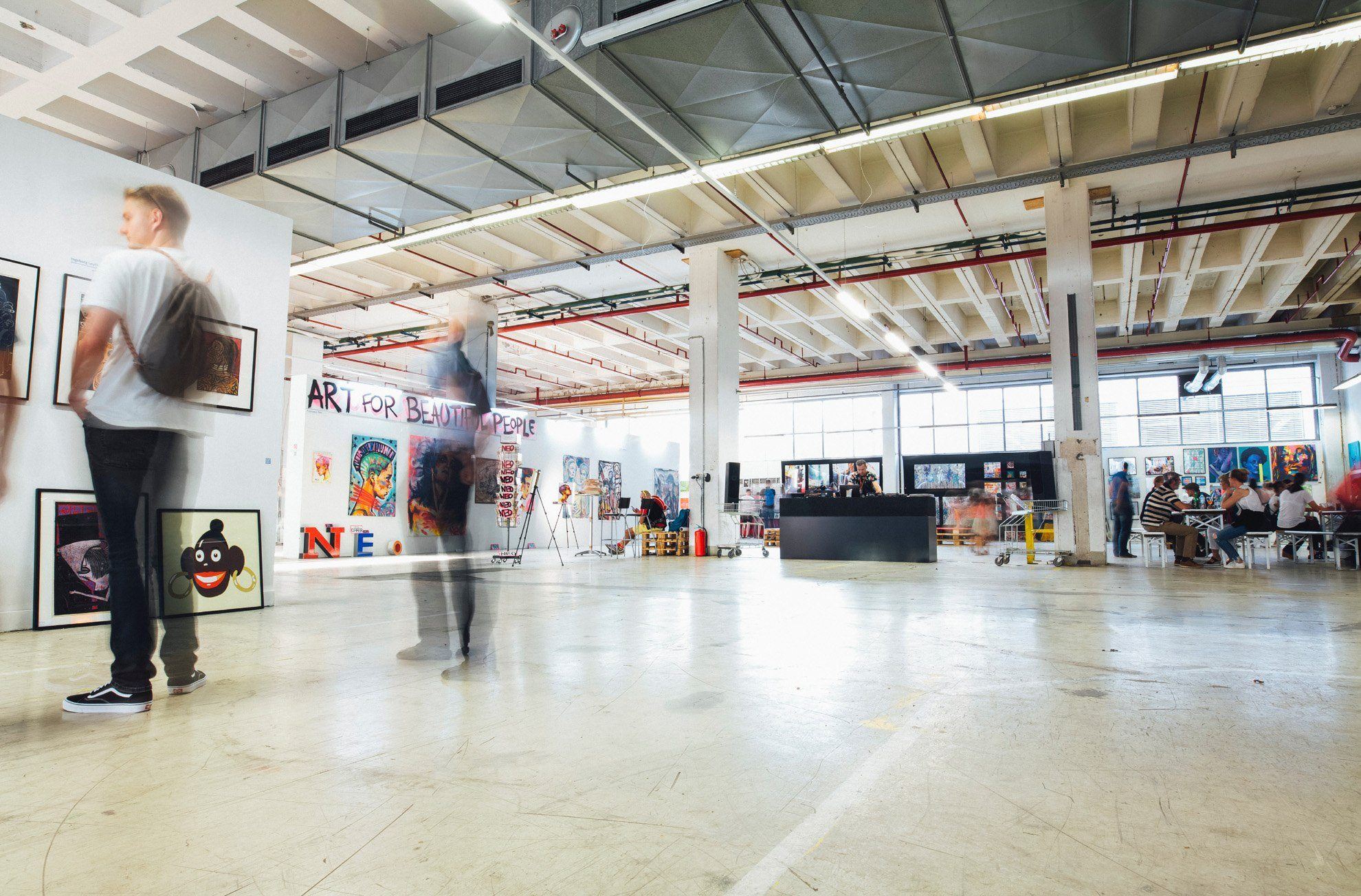 Event cleaning services NYC. A recently cleaned event space with visitors looking at artwork. Exhibit venue cleaning services NYC