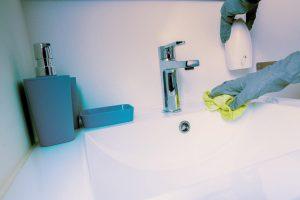 Office bathroom sink being cleaned with an environmentally friendly cleaning product. Office cleaners, NYC.