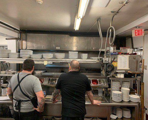 Staff looking at kitchen. Restaurant cleaning services NYC are provided by professional kitchen cleaning companies in New York City to keep kitchens like this clean.