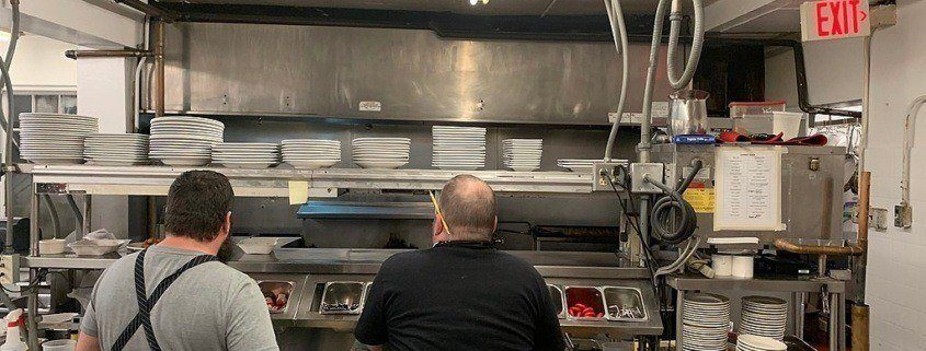 Staff looking at kitchen. Restaurant cleaning services NYC are provided by professional kitchen cleaning companies in New York City to keep kitchens like this clean.
