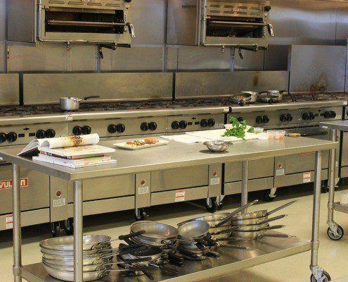 image of a restaurant kitchen. Cleaning services in New York city help ensure that all facets of the kitchen are cleaned including the kitchen exhaust hood. Cleaning NYC commercial kitchens is performed by professional companies like SanMar.