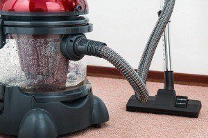 New York City carpet cleaning being performed in a commercial building with a carpet steam cleaning vacuum. NYC commercial carpet cleaning services are offered by SanMar.