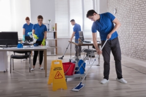 Janitorial staff in NYC cleaning a commercial office with environmentally friendly cleaning supplies.