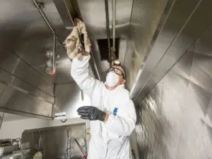 NYC kitchen exhaust hood cleaning services in Manhattan being performed by a SanMar employee.