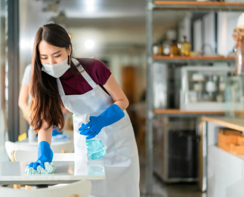 An outsourced retail cleaning professional using a customized checklist to clean and maintain different areas of a retail store including high-touch surfaces.