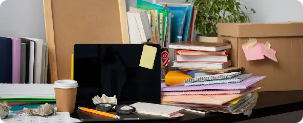 confidential-office-security A cluttered desk with messy papers, a laptop, and open files, highlighting confidential office security risks and unsecure data.