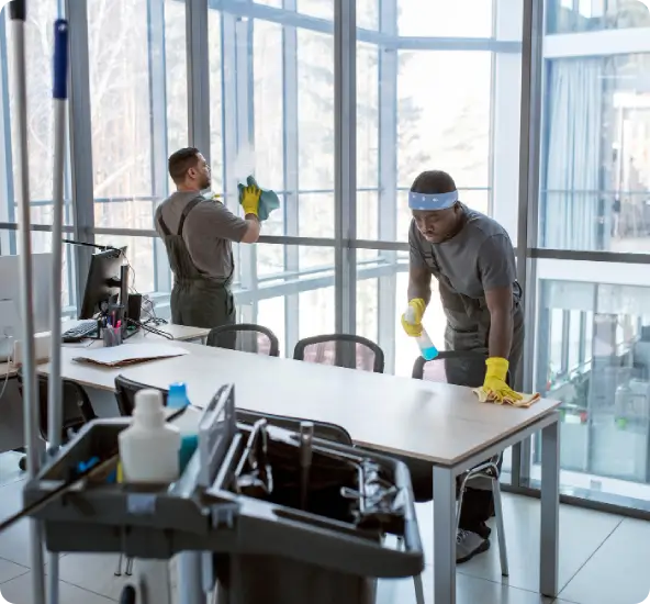 secure-cleaning-program Janitorial team cleaning a modern corporate conference room, a key step when implementing a reliable, secure cleaning program.